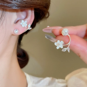 Detail view of silver floral earrings featuring white pearls and sparkling leaf-shaped crystals