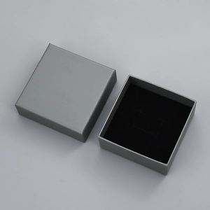 Detailed top view of a minimalist square gray jewelry gift box with black velvet lining