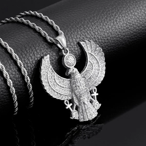 Macro detail of silver eagle pendant with sparkling crystals on black leather background