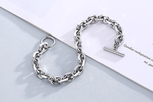 Detail of silver stainless steel Cuban link bracelet with OT toggle clasp on a card