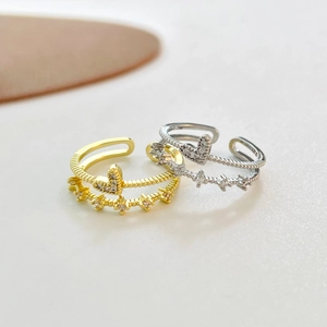 Dettaglio anello a cuore a doppio strato regolabile con finiture oro e argento e zirconi