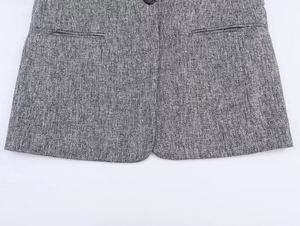Detail of grey textured blazer showing symmetric pockets and fine blend knit fabric