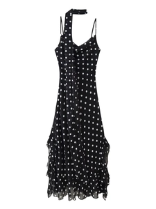 Detailed view of black polka dot dress featuring tiered ruffle hem and halter neck straps