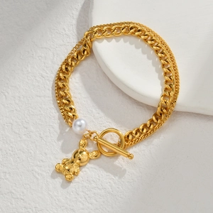 Goldenes zweischichtiges Kettenarmband mit Bärenanhänger und einer weißen Perle als Akzent