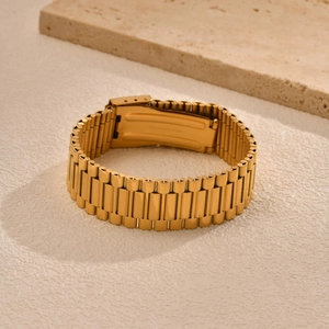 Close-up of golden heavy duty link bracelet with folding clasp on stone texture