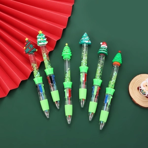 Close-up of Christmas multi-color ballpoint pens with Santa and tree toppers