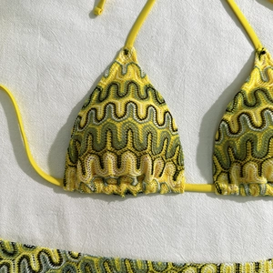 Détail du haut de bikini au crochet jaune avec broderie verte et design à lacets