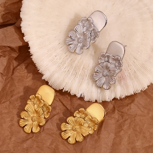 Detailed view of vintage triple daisy floral stud earrings in gold and silver finishes