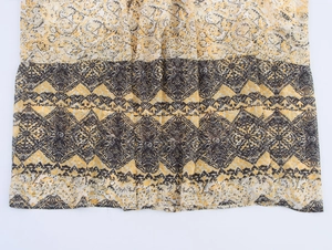 Detailed view of yellow and black ethnic print fabric with lightweight textile texture