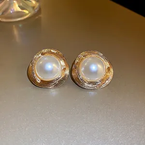 Vintage style gold intertwined textured earrings with elegant white pearl center studs