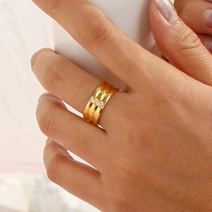 Detail of 18K gold-plated triple band ring featuring three elegant cubic zirconia stones