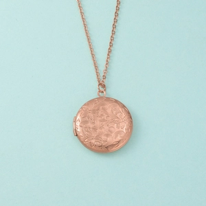 Détail du médaillon en acier 316L or rose avec gravure florale rétro sur la chaîne