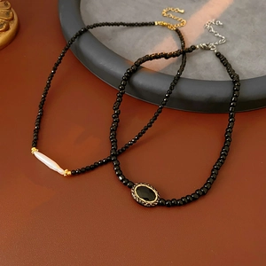 Detail of vintage freshwater pearl necklaces with black crystal beads on leather surface