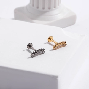 Detail of silver and gold G23 titanium labret studs with cubic zirconia flowers