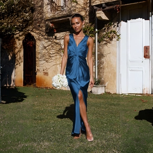 Détail d'une élégante robe de soirée en satin bleu foncé avec col en V et fente haute