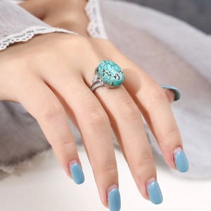 S925 sterling silver ring featuring oval turquoise and cubic zirconia on a model's finger