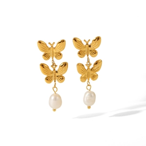 Detail of 18K gold butterfly earrings featuring elegant white hanging pearls