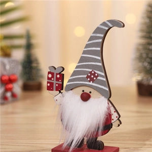 Gnome de Noël en bois avec bonnet rayé et barbe blanche tenant un coffret cadeau