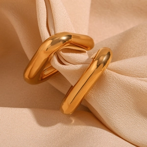 Macro shot of 18K gold plated ring with geometric texture on silk fabric