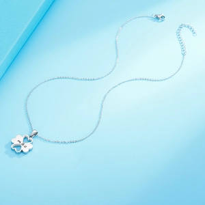 Silver four-leaf clover necklace with heart cutouts and 'mae' engraving on blue background