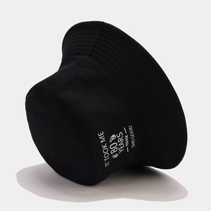 Detail of black cotton bucket hat with 80th birthday slogan and sharp white print