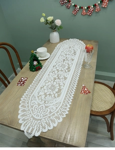 Close-up of white rectangle lace table runner with floral patterns and tassel edges