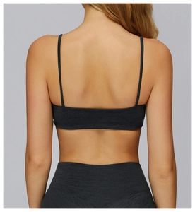Dettaglio della schiena scoperta con doppie spalline sul reggiseno sportivo grigio