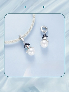 Macro view of a 925 sterling silver snowman pendant with white pearl and black enamel hat