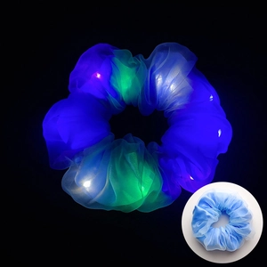 Détail du chouchou LED en résille bleue montrant l'effet lumineux et le tissu fin