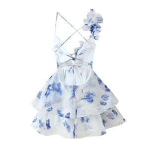 Détail de robe fleurie blanche avec fleur 3D à l'épaule et design dos nu à lacets