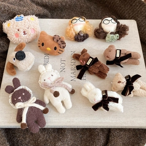 Detailed view of assorted soft flocked bear and kitten pins on a rustic fabric background