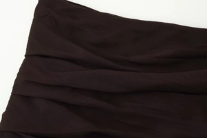 Detailed macro view of dark semi-transparent pleated fabric texture on dress
