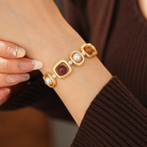 Détail d'un bracelet doré vintage orné de perles et de pierres précieuses colorées