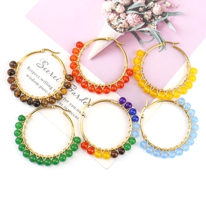 Detailed view of handmade gold wire-wrapped hoop earrings with colorful natural stone beads