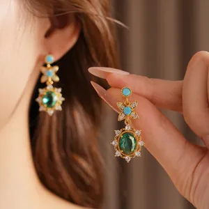 Vintage gold earrings with oval green gemstone and white zircon flower halo detail