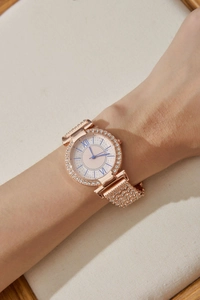 Dettaglio di un orologio di lusso in oro rosa per donna con diamanti e numeri romani al polso