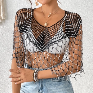 Détail du cache-maillot noir au crochet avec perles blanches et texture ondulée élégante