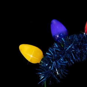 Detail of glowing yellow and blue bulb headband with sparkling tinsel for Christmas party