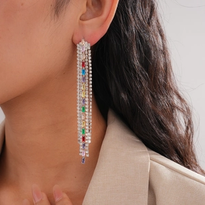 Detailed view of luxury rainbow tassel earrings with colorful zircons worn by model