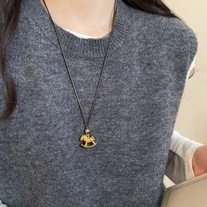 Golden rocking horse pendant necklace with zircon and tiger eye stone on model