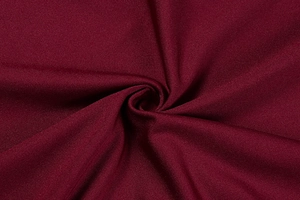 Macro detail of burgundy red fabric with fine twill texture and subtle silky sheen