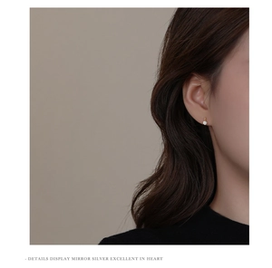 Detail view of a minimalist gold sterling silver stud earring with a sparkling zircon