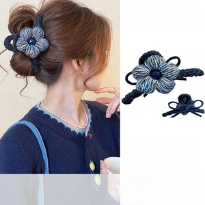 Détail de la pince à cheveux avec fleur tricotée bleu marine design nœud et perle centrale