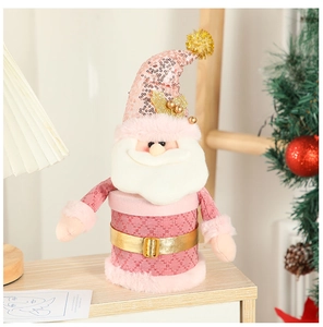 Close-up of pink Santa Claus candy jar with golden belt and sequins on wooden table