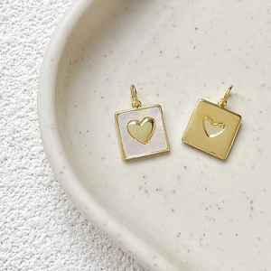 Close-up of heart-shaped gold pendants with mother-of-pearl inlay for DIY jewelry design