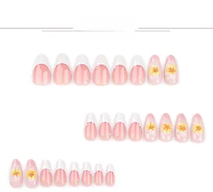 Detailed view of almond press-on nails with 3D sun flowers, pearls, and French tips