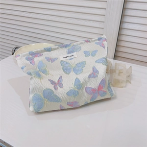 Macro detail of butterfly jacquard fabric and simple wish label on canvas makeup bag