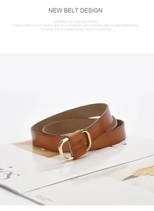 Close-up of a rolled brown leather belt on a magazine showcasing texture and buckle