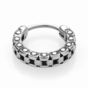 Macro shot of silver earring with gear-style rivet texture for punk fashion style