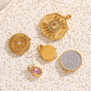 Detail of 18K gold plated stainless steel coin pendants with crystals on stone base